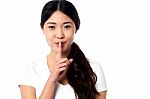 Beautiful Asian Girl Gesturing Silence Stock Photo