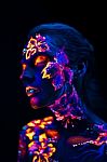 Beautiful Flowers In Uv Light On A Young Girl Face And Body Stock Photo