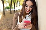 Beautiful Girl Chatting With Mobile Phone In Autumn Stock Photo