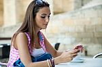 Beautiful Girl Drinking Coffee And Texting With Mobile Phone Stock Photo