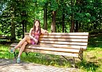 Beautiful Girl Sitting On A Park Bench Stock Photo