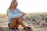 Beautiful Girl Sitting On The Roof And Listening To Music Stock Photo