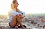 Beautiful Girl Sitting On The Roof And Listening To Music Stock Photo