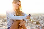 Beautiful Girl Sitting On The Roof And Listening To Music Stock Photo