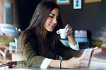 Beautiful Girl Using Her Mobile Phone In Cafe Stock Photo