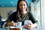 Beautiful Girl Using Her Mobile Phone In Cafe Stock Photo