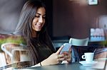 Beautiful Girl Using Her Mobile Phone In Cafe Stock Photo