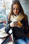 Beautiful Girl Using Her Mobile Phone In Cafe Stock Photo