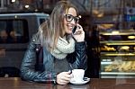 Beautiful Girl Using Her Mobile Phone In Cafe Stock Photo