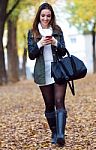 Beautiful Girl Walking With Mobile Phone In Autumn Stock Photo