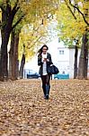 Beautiful Girl Walking With Mobile Phone In Autumn Stock Photo