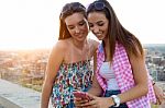 Beautiful Girls Sitting On The Roof And Listening To Music At Su Stock Photo