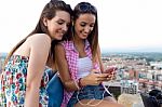 Beautiful Girls Sitting On The Roof And Listening To Music At Su Stock Photo