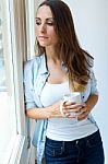 Beautiful Woman Drinking Coffee In The Morning Near The Window Stock Photo