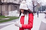 Beautiful Woman In Red Coat And Wool Cap And Gloves With Smartph Stock Photo