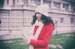 Beautiful Woman In Red Coat And Wool Cap And Gloves With Smartph Stock Photo