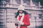 Beautiful Woman In Red Coat And Wool Cap And Gloves With Smartph Stock Photo