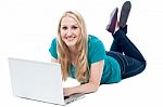 Beautiful Woman Lying On The Floor, Using Laptop Stock Photo