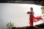 Beautiful Woman Wear Red Evening Dress Hold A Bouquet Of Flowers Stock Photo