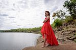 Beautiful Woman Wear Red Evening Dress Over Mountains And Rivers Stock Photo