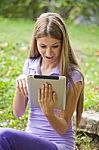 Beautiful Woman With Tablet Computer In Park Stock Photo