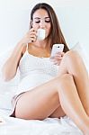 Beautiful Young Woman Drinking Coffee And Using Mobile Phone On Stock Photo