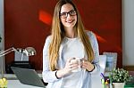 Beautiful Young Woman Drinking Coffee In The Office Stock Photo