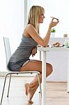 Beautiful Young Woman Enjoying Breakfast In The Kitchen Stock Photo