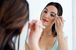 Beautiful Young Woman Making Make-up Near Mirror Stock Photo