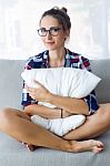 Beautiful Young Woman Relaxing On Sofa At Home Stock Photo