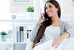 Beautiful Young Woman Talking On The Phone At Home Stock Photo