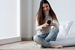 Beautiful Young Woman Using Her Mobile Phone At Home Stock Photo