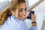 Beautiful Young Woman Using Her Mobile Phone At Home Stock Photo