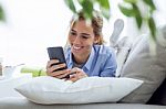 Beautiful Young Woman Using Her Mobile Phone At Home Stock Photo