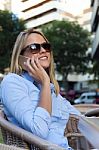 Beautiful Young Woman Using Her Mobile Phone In A Restaurant Ter Stock Photo