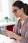 Beautiful Young Woman Using Her Mobile Phone In The Office Stock Photo