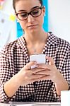 Beautiful Young Woman Using Her Mobile Phone In The Office Stock Photo