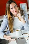 Beautiful Young Woman Using Her Mobile Phone In The Office Stock Photo