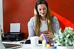 Beautiful Young Woman Using Her Mobile Phone In The Office Stock Photo