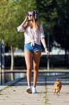 Beautiful Young Woman Walking With Her Dog In The Park Stock Photo