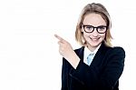 Bespectacled Business Girl Pointing Away Stock Photo