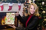 Blonde Female Holding Gift In Holiday Scene Stock Photo