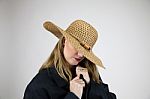 Blonde Female In Large Hat And Coat Hiding Face Stock Photo