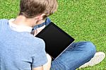 Boy With Crossed Legs Relaxing Outdoors Stock Photo