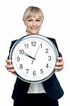 Business Executive Displaying Big Wall Clock Stock Photo