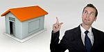 Business Man Gesturing With Hand And Three Dimensional House Stock Photo