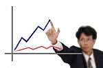 Business Man Point To Top Of Blue Line Graph Stock Photo