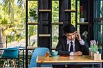 Business Man Using Mobile Phone While Sitting In The Coffee Shop Stock Photo