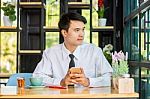 Business Man Using Mobile Phone While Sitting In The Coffee Shop Stock Photo