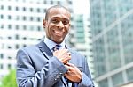 Businessman Adjusting His Collar Outdoors Stock Photo